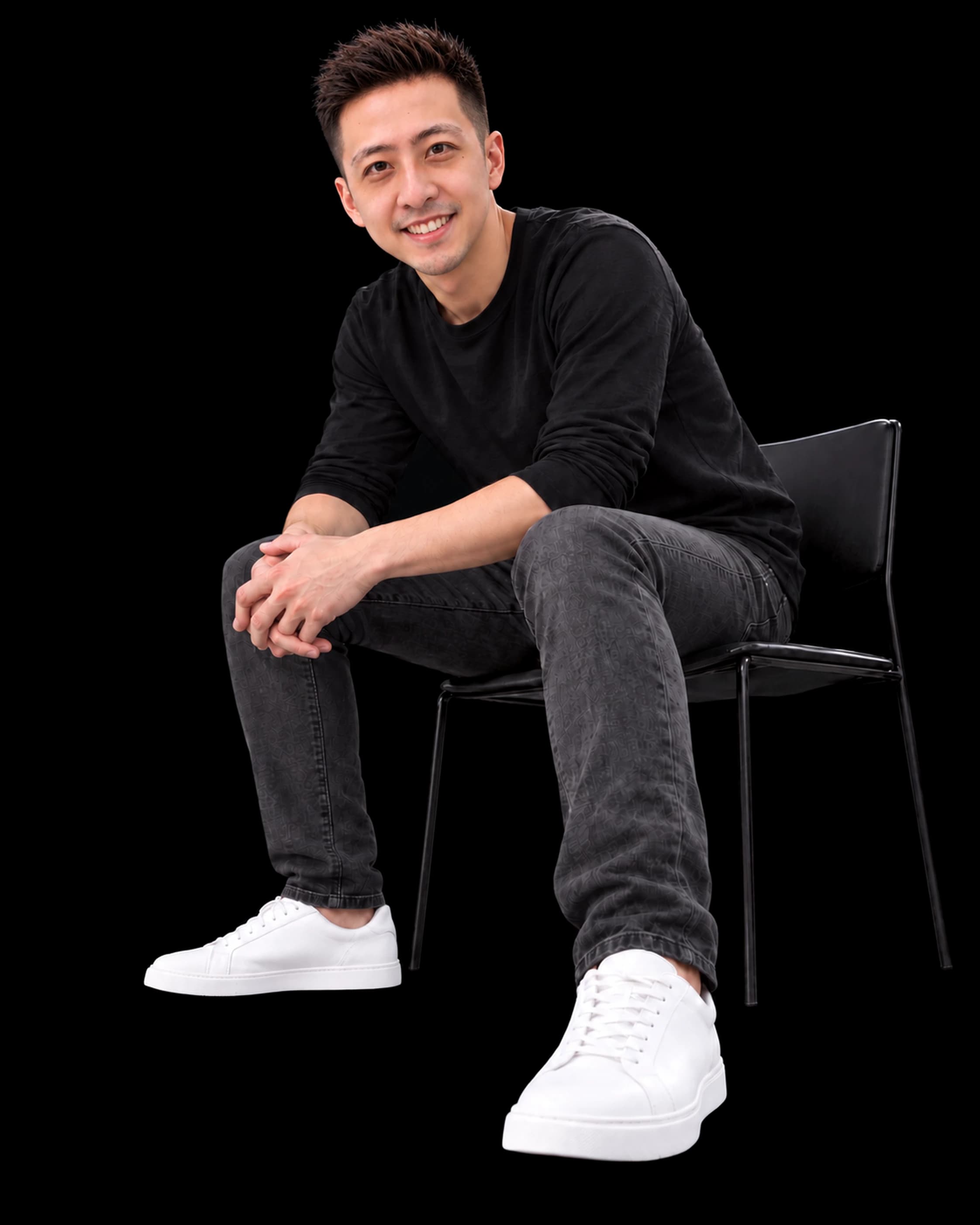 Karl Khang, smiling, seated on a black chair